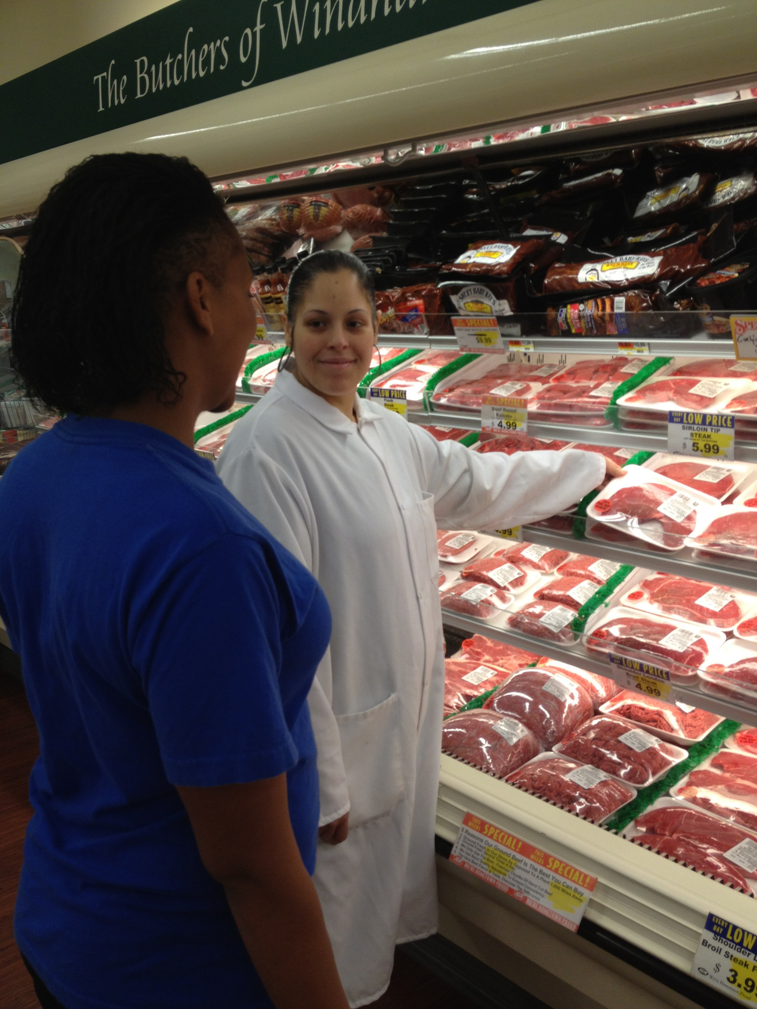 Butcher helping customer